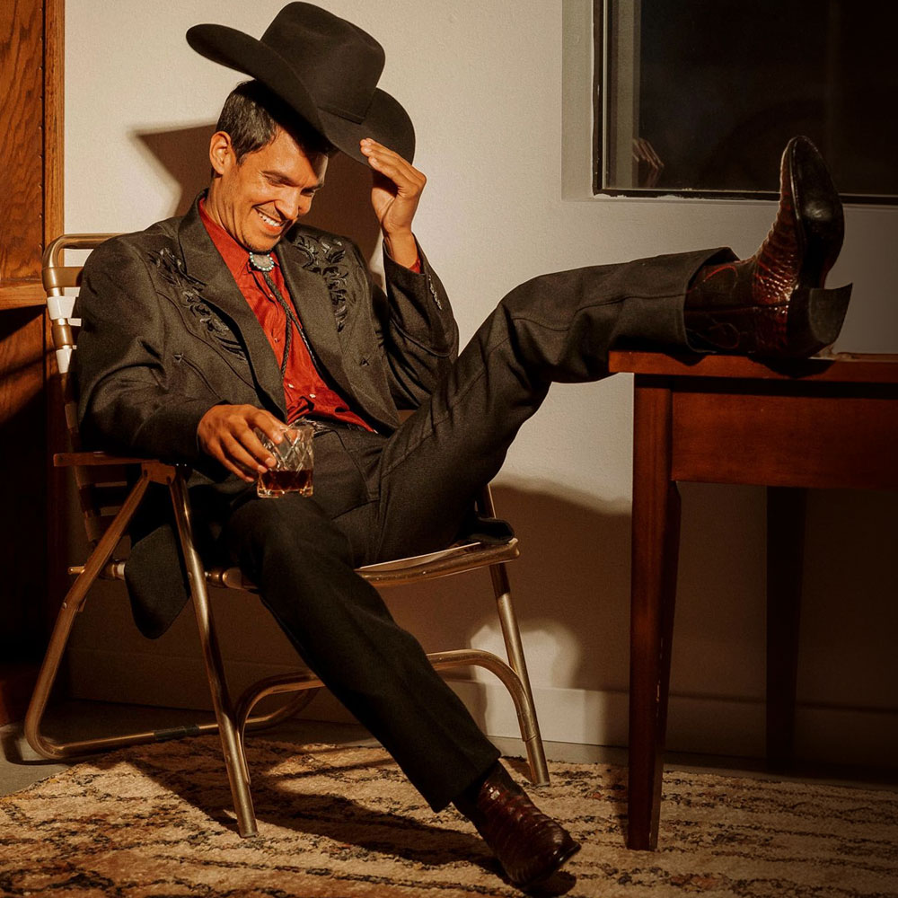 A man sitting on an office chair wearing Signature Series Boots.